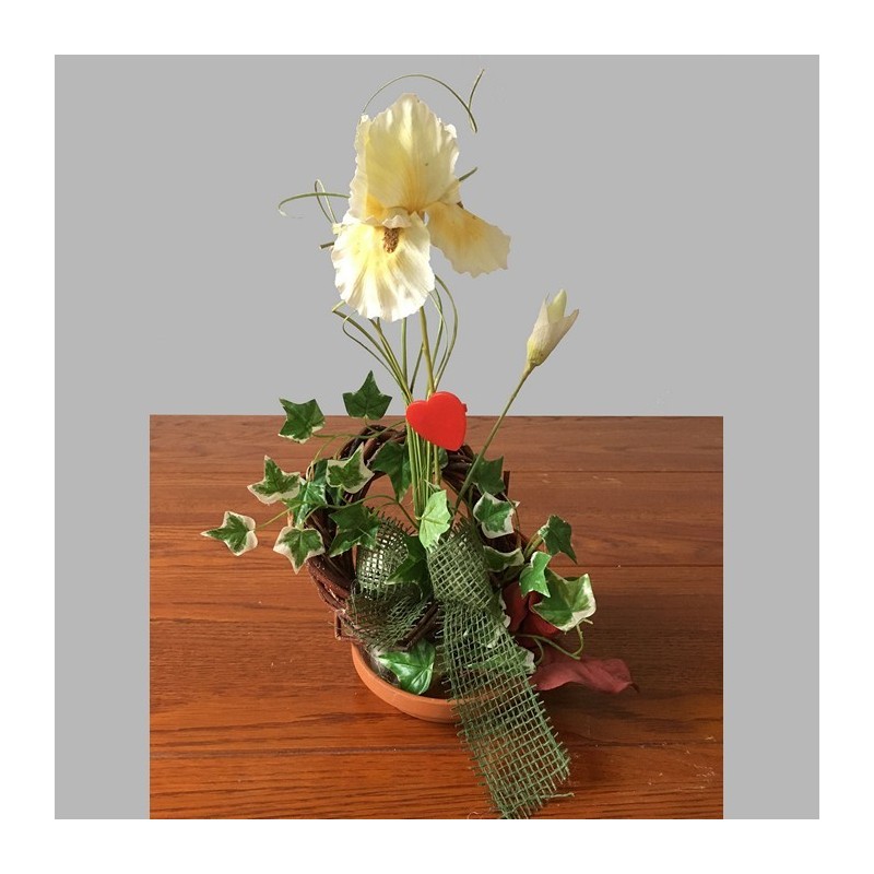 Composition florale avec iris dans un plat rond en terre cuite