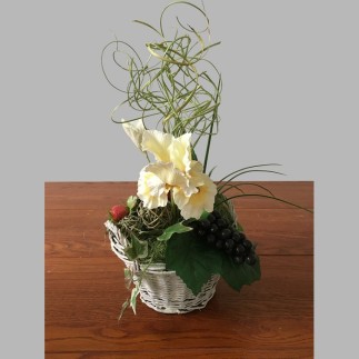 Composition florale avec iris et raisins dans un panier