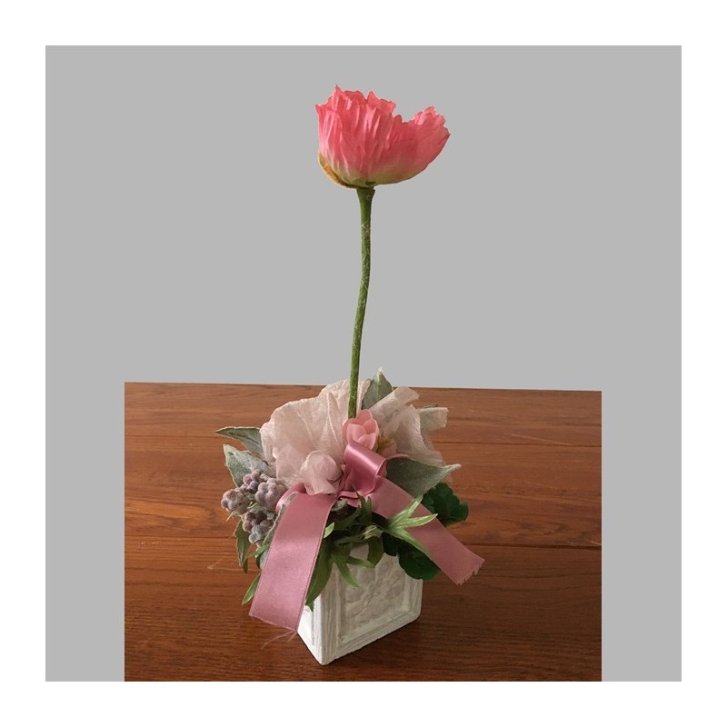 Composition florale avec baies et fleurs dans un pot carré en céramique