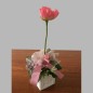 Composition florale avec baies et fleurs dans un pot carré en céramique