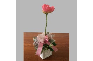 Composition florale avec baies et fleurs dans un pot carré en céramique