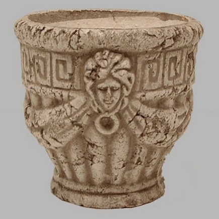 Stenen bloempot met hoofden bewerkt