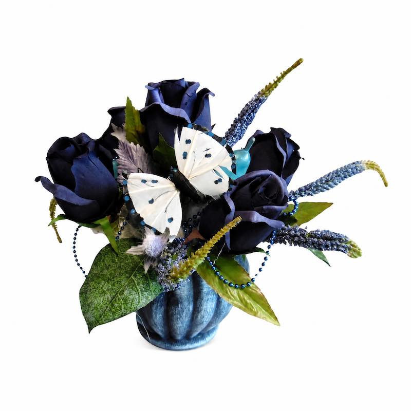 Blauw bloemstuk in pot met vlinder