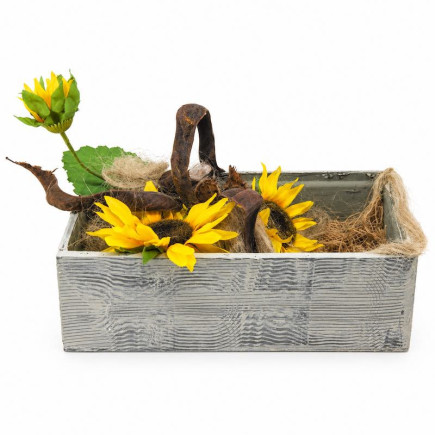 Yellow artificial sunflowers with a tall flower bud, curved brown branch, flax and jute in a wooden box